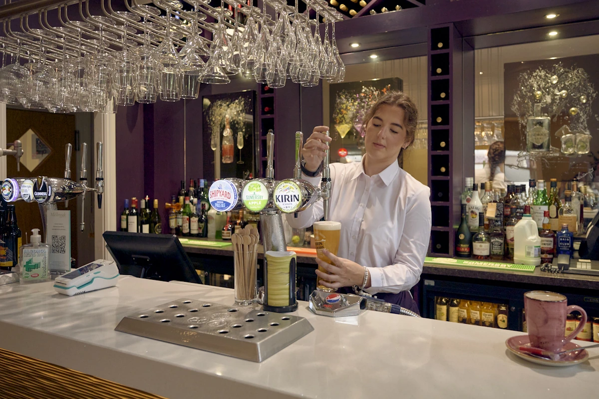 Bar staff pouring a drink
