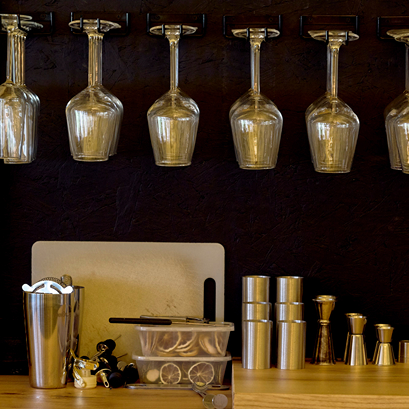 Wine glasses hanging upside down above a bar