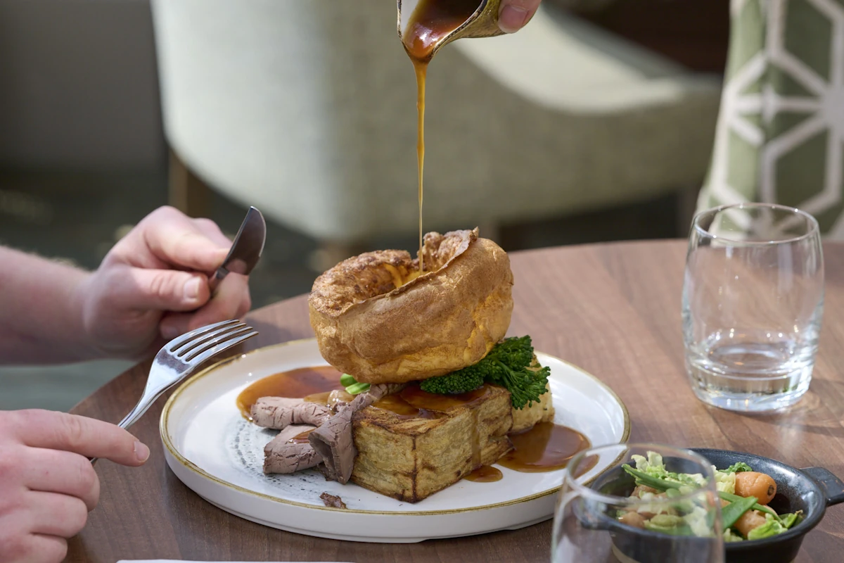 Pouring gravy over Sunday lunch