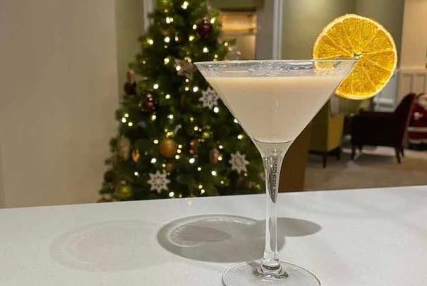 A Bailey's Cocktail in front of a lit Christmas tree