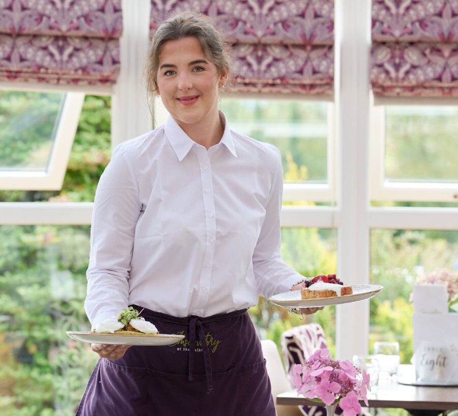 Waiting staff with plates of food in the Conservatory restaurant